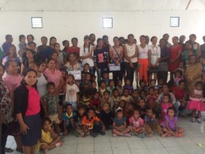 Group of parents and young children inside hall lined up