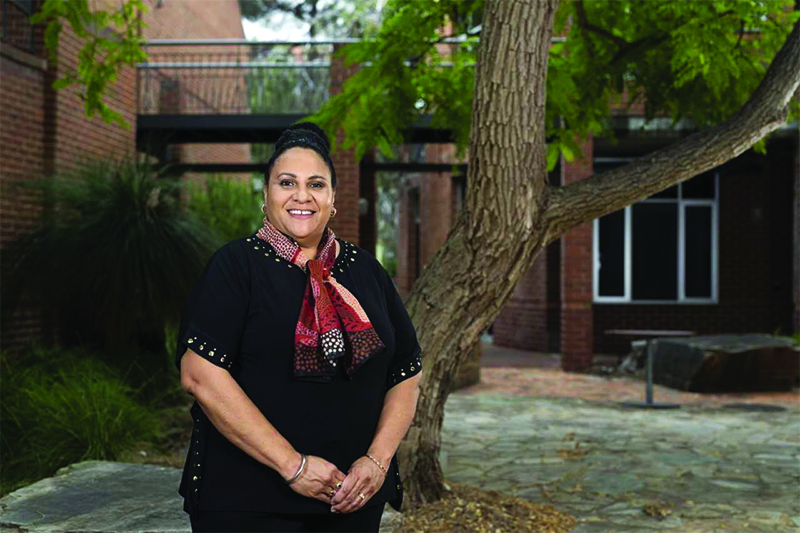 Scholar standing in front of tree, facing camera.