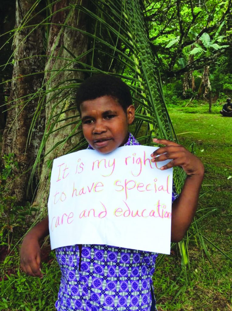 PNG Boy holding hand drawn sign saying it is my right to have special care and education