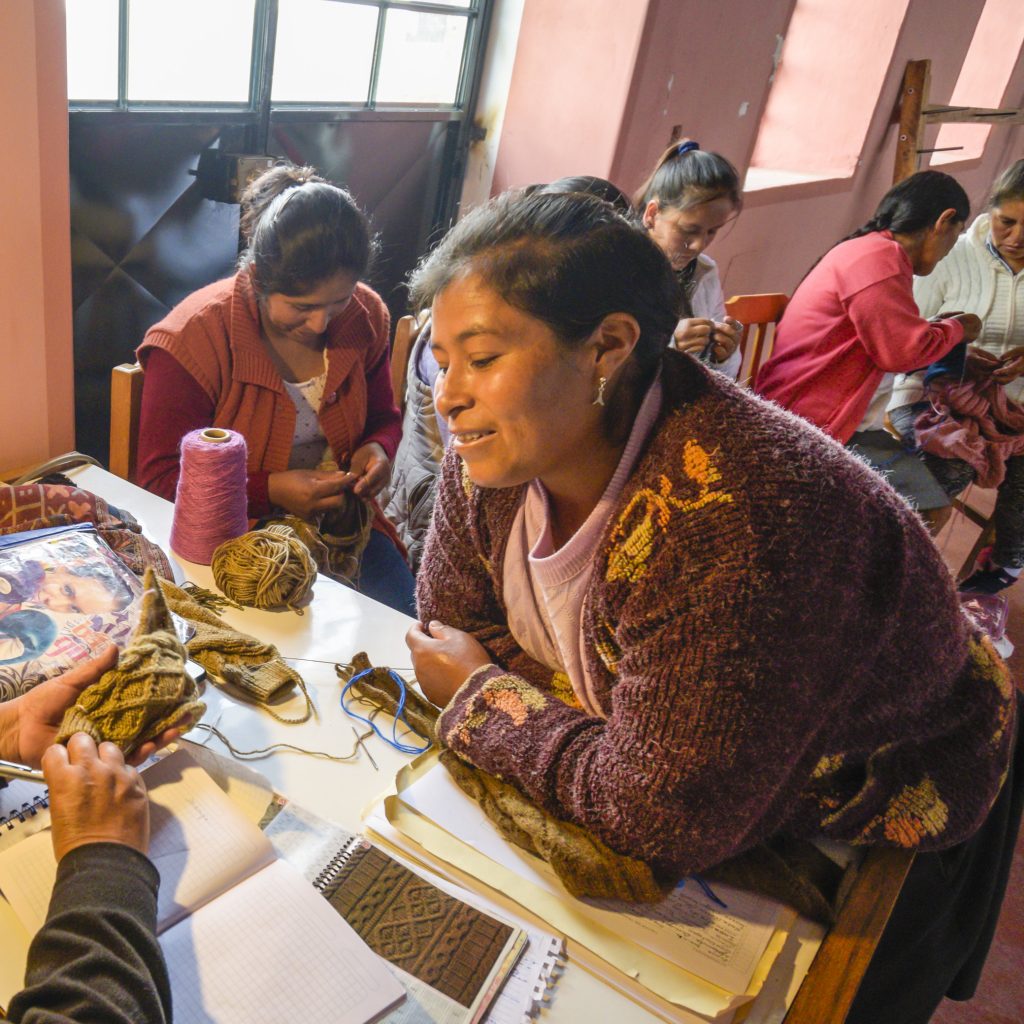 Two Peruvian women knitting in a workshop