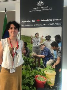 Staff Member from Mary MacKillop Today standing in front of a banner for PNG Australian Aid Friendship Grant