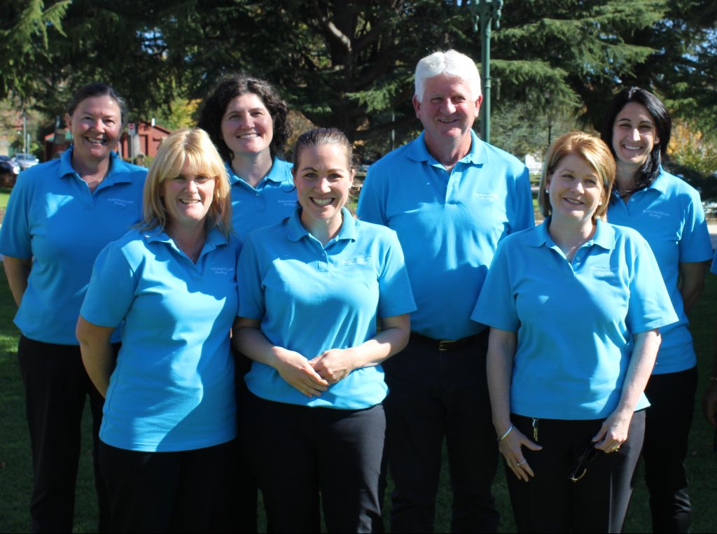 Members of the financial inclusion team in a park in Bathurst smiling at the camera