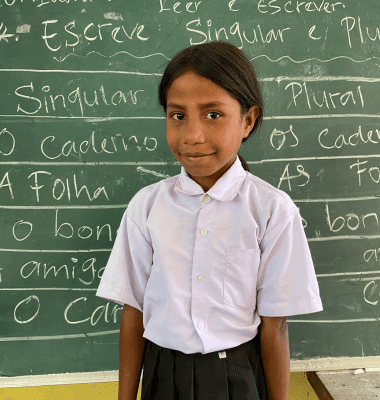 Student standing in front of blackboard
