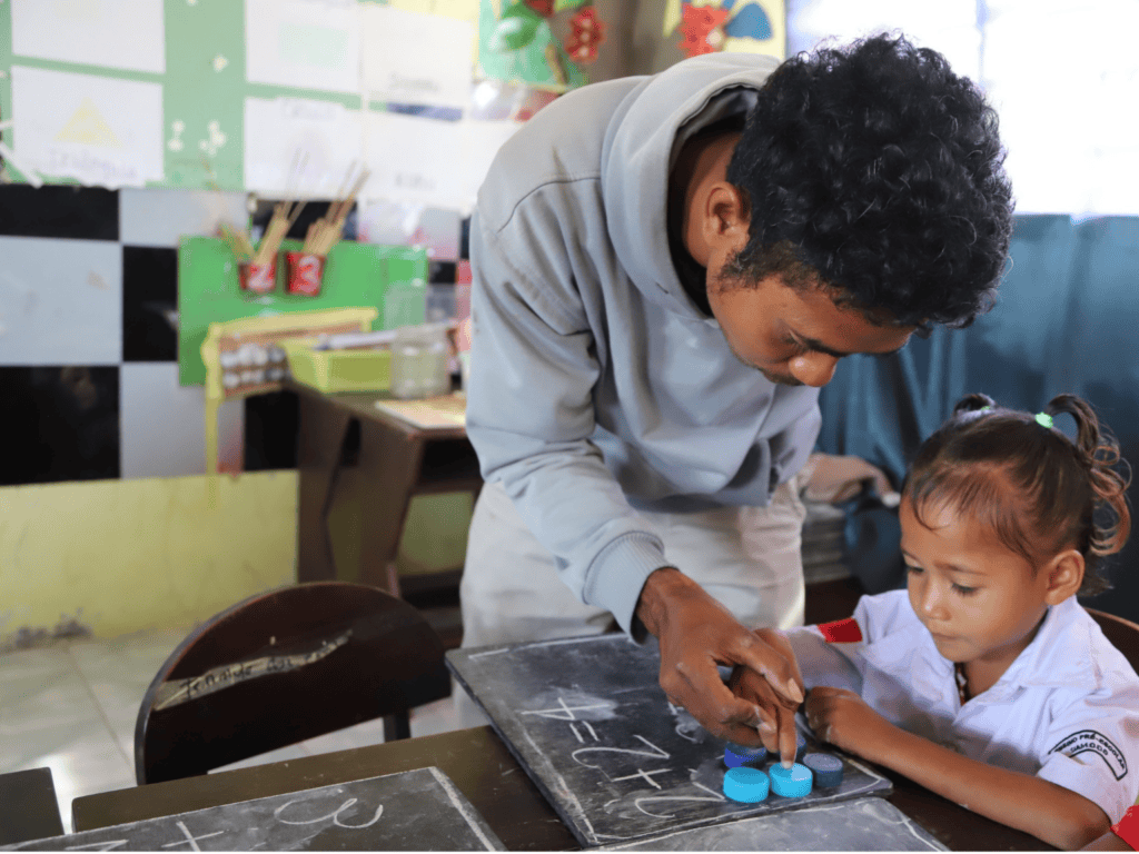 Teacher with student in Timor-Leste